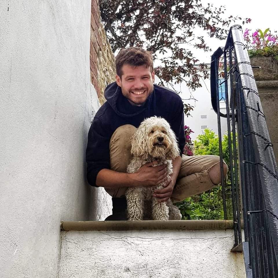 Charles Alexander in his Brighton garden with a dog.